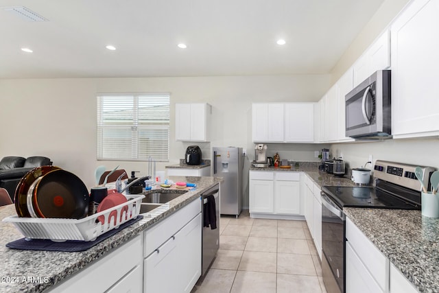 kitchen featuring sink, white cabinetry, stainless steel appliances, and light tile patterned floors