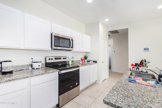 kitchen with white cabinetry, sink, light tile patterned floors, and appliances with stainless steel finishes