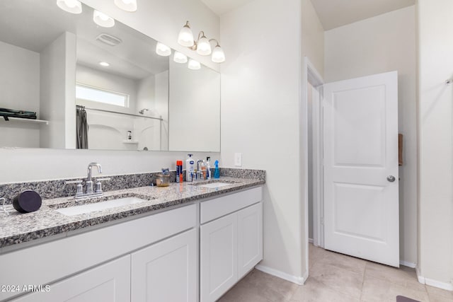 bathroom with tile patterned flooring, vanity, and walk in shower