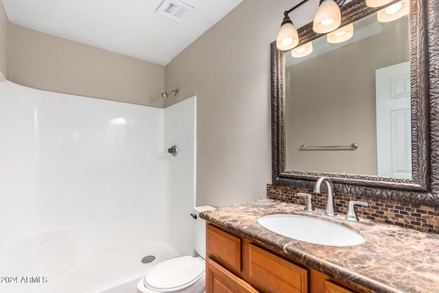 bathroom with tasteful backsplash, vanity, walk in shower, and toilet