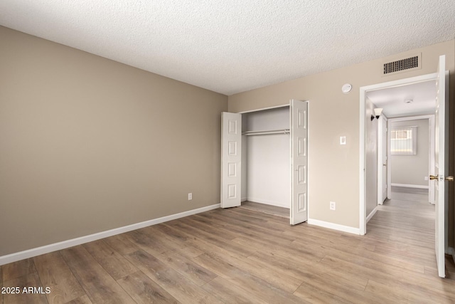 5625 N 47th Ave, Glendale, AZ 85301 - unfurnished bedroom with light wood finished floors, a closet, a textured ceiling, and baseboards