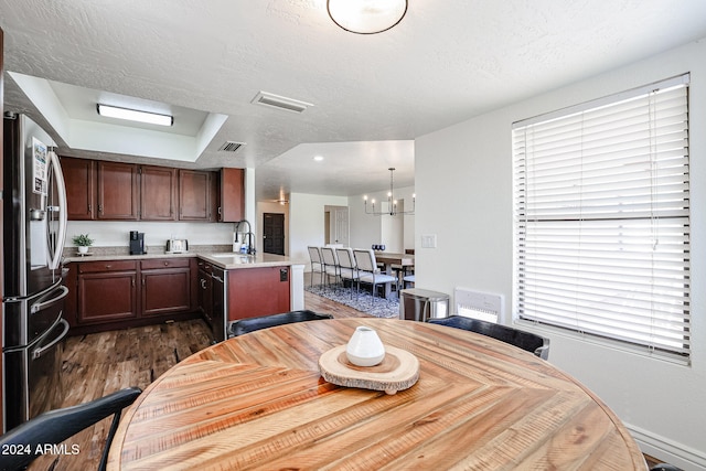 dining area featuring a textured ceiling, dark hardwood / wood-style floors, and sink