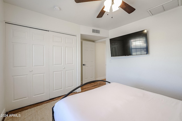 bedroom with light hardwood / wood-style flooring, a closet, and ceiling fan