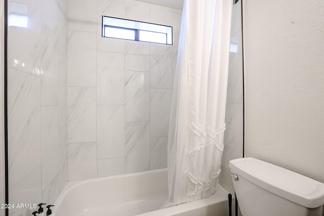 bathroom featuring shower / bath combo and toilet