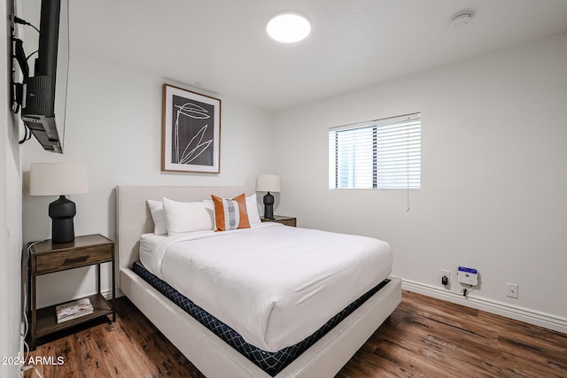 bedroom with dark hardwood / wood-style flooring