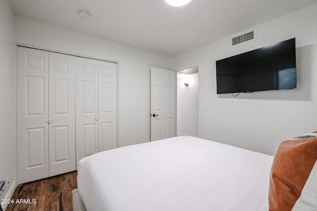 bedroom with dark hardwood / wood-style flooring and a closet