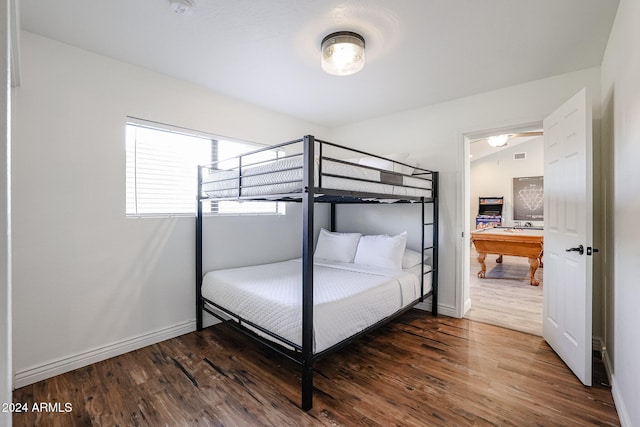 bedroom with dark hardwood / wood-style floors, vaulted ceiling, and pool table