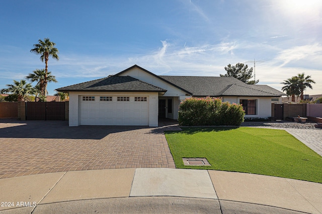 ranch-style house featuring a front lawn and a garage