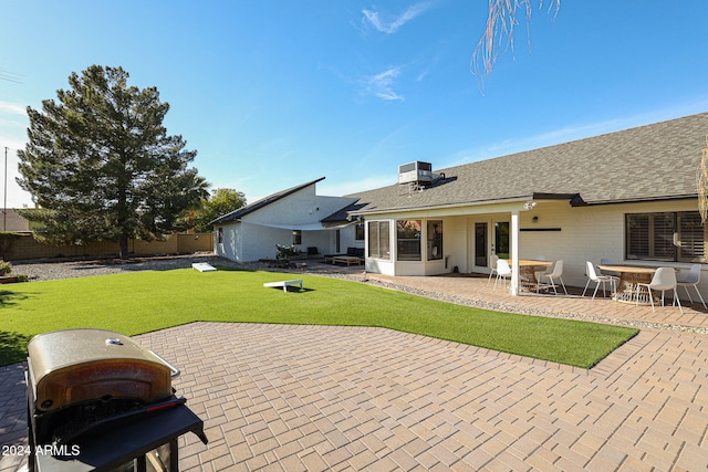 back of property with a lawn, central AC, and a patio