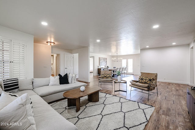 living room featuring an inviting chandelier and light wood-type flooring