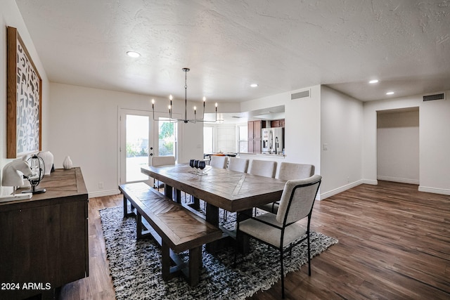 dining area with a chandelier, a textured ceiling, and hardwood / wood-style flooring