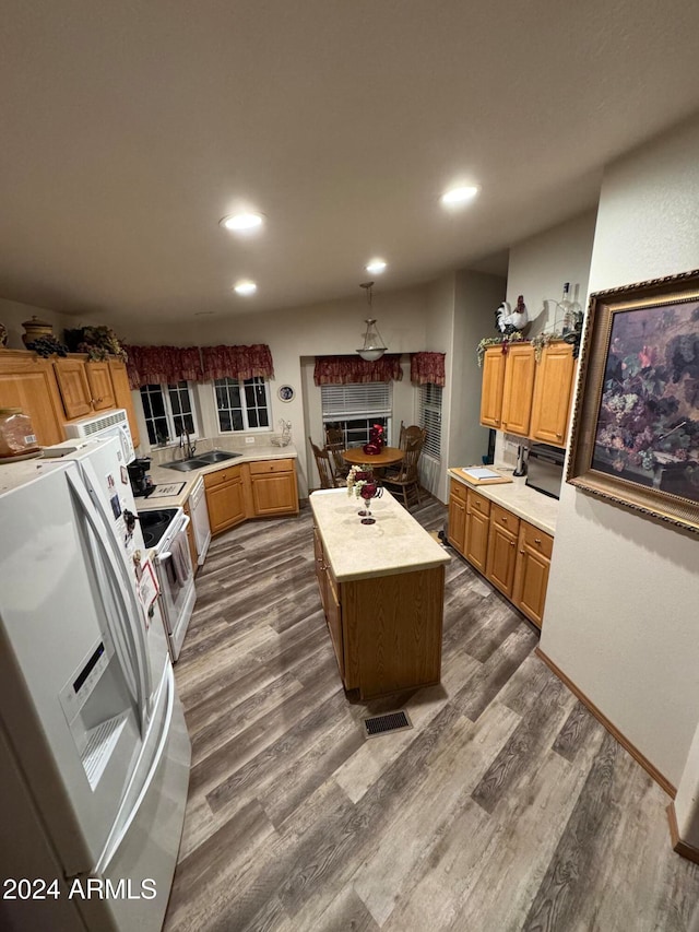 kitchen with a kitchen island, sink, white appliances, and dark wood-type flooring