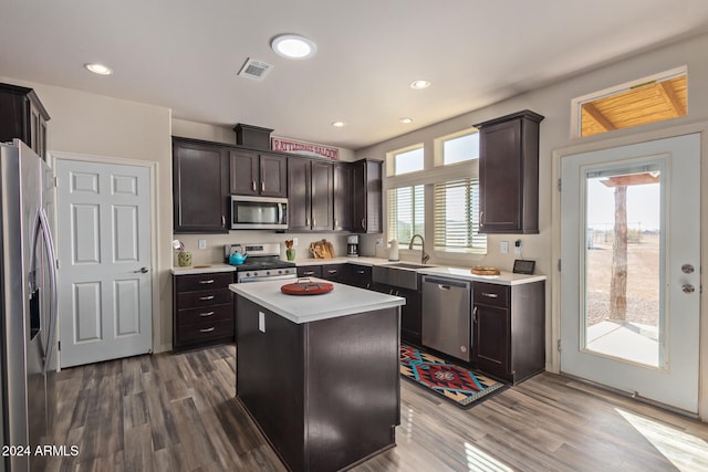 kitchen with a center island, stainless steel appliances, a wealth of natural light, and dark wood-type flooring