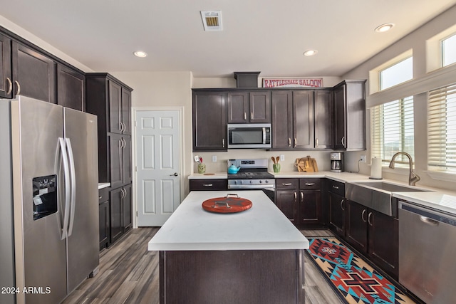 kitchen with dark hardwood / wood-style flooring, a center island, dark brown cabinets, and appliances with stainless steel finishes