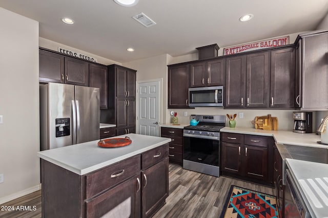 kitchen with dark hardwood / wood-style floors, a kitchen island, dark brown cabinetry, and appliances with stainless steel finishes