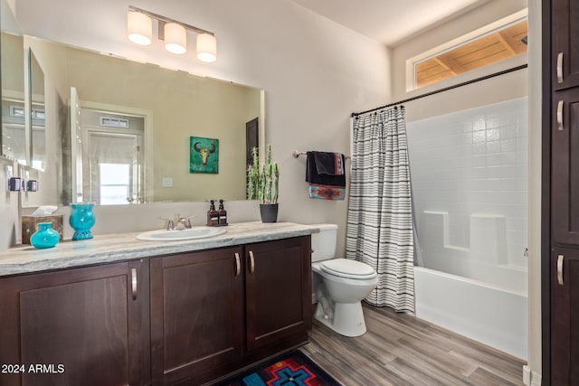 full bathroom with hardwood / wood-style floors, vanity, toilet, and shower / tub combo