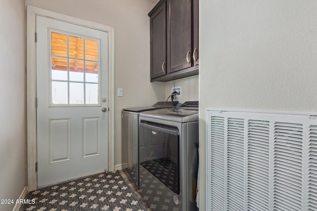 laundry room featuring separate washer and dryer and cabinets