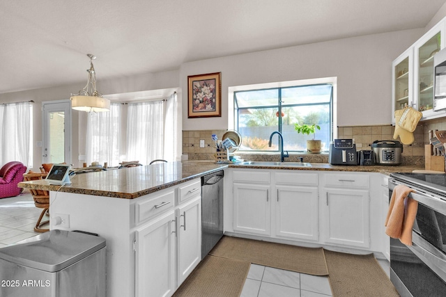 kitchen featuring kitchen peninsula, white cabinetry, sink, and light tile patterned flooring