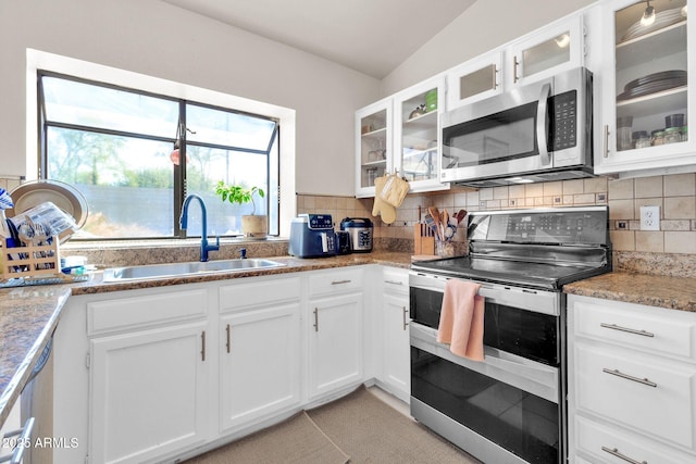 kitchen with white cabinets, appliances with stainless steel finishes, tasteful backsplash, and sink