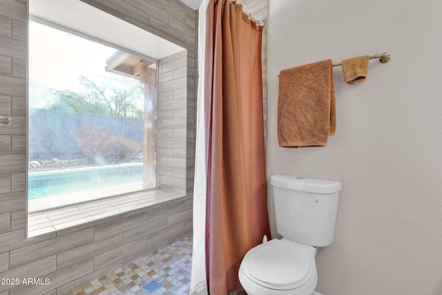 bathroom with toilet and curtained shower