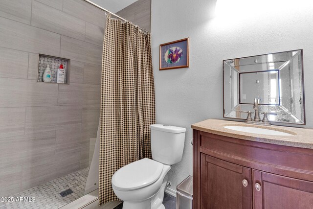 bathroom featuring walk in shower, vanity, and toilet