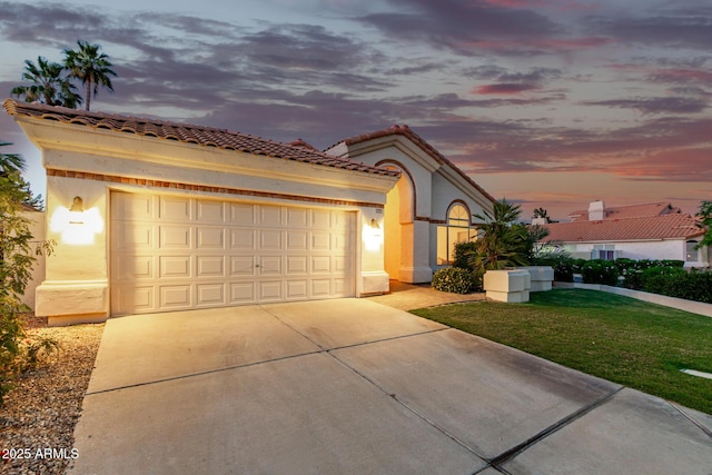 mediterranean / spanish home featuring concrete driveway, a garage, stucco siding, and a front lawn