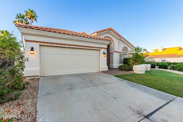 mediterranean / spanish house featuring driveway, a garage, a front yard, stucco siding, and a tiled roof