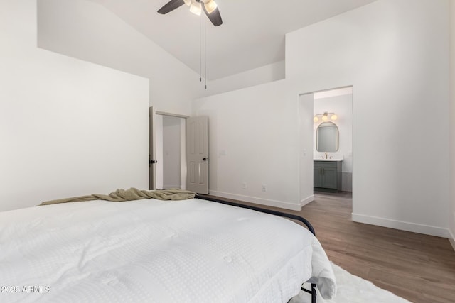 bedroom with wood finished floors, high vaulted ceiling, baseboards, a ceiling fan, and ensuite bath