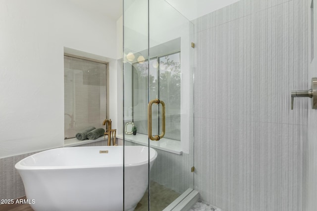bathroom with a soaking tub and a shower stall