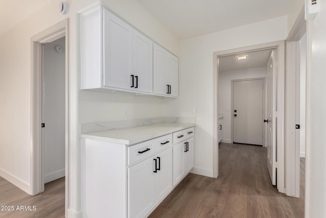 hall featuring light wood-style floors and baseboards