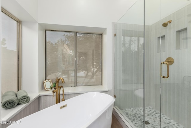 bathroom featuring a shower stall and a soaking tub