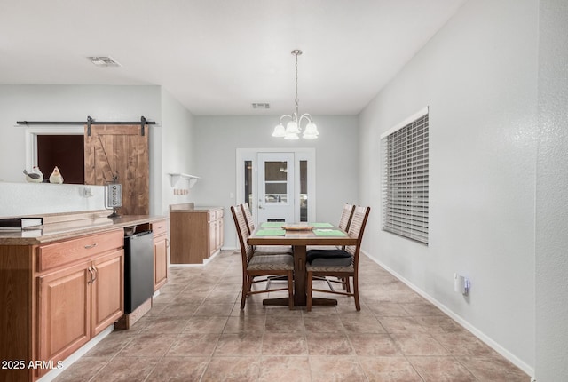 tiled dining area featuring an inviting chandelier and a barn door