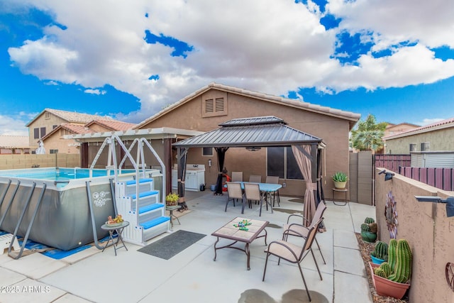 view of patio / terrace with a fenced in pool and a gazebo