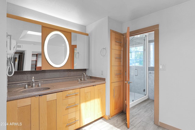 bathroom with a shower with door, vanity, and wood-type flooring