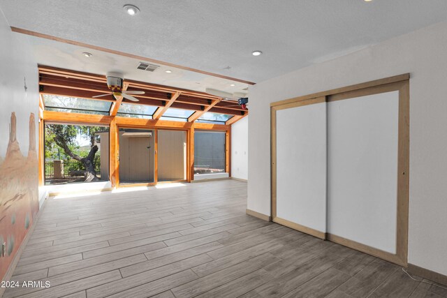 interior space with visible vents, wood finished floors, recessed lighting, a skylight, and baseboards