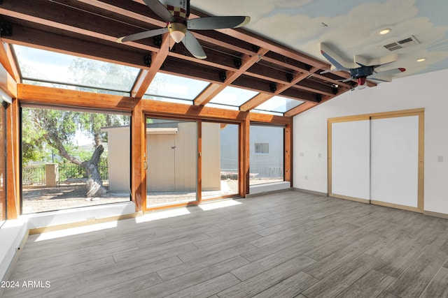 unfurnished sunroom featuring visible vents, beamed ceiling, a skylight, and a ceiling fan