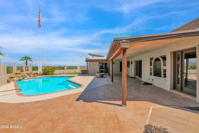 pool with a patio area and fence