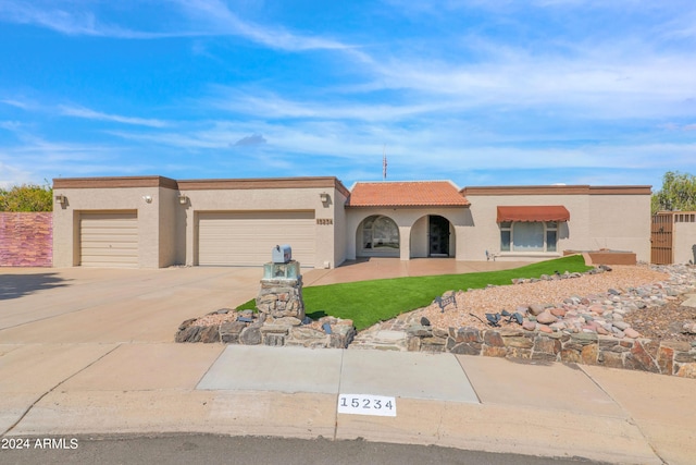 view of front of home with a tile roof, concrete driveway, a garage, and stucco siding