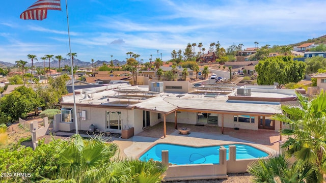 rear view of house featuring a fenced backyard, a residential view, an outdoor pool, and a patio