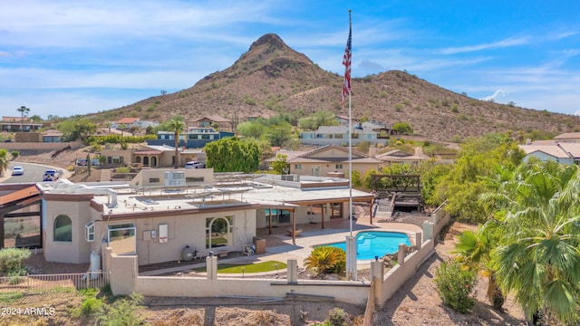 rear view of house featuring stucco siding, a mountain view, a fenced backyard, and a patio