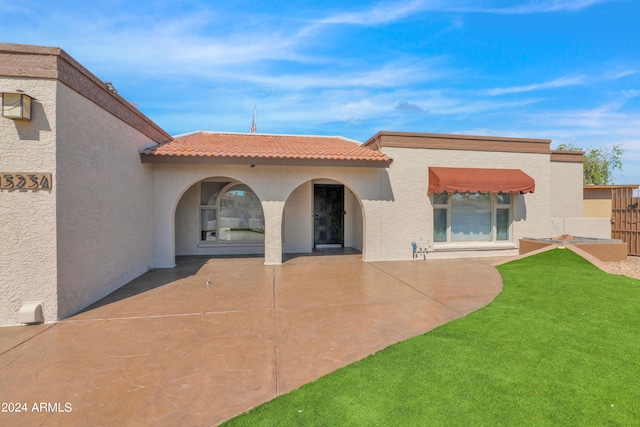 rear view of house with a yard and a patio area