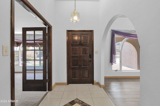 entryway with plenty of natural light, light hardwood / wood-style flooring, and a chandelier