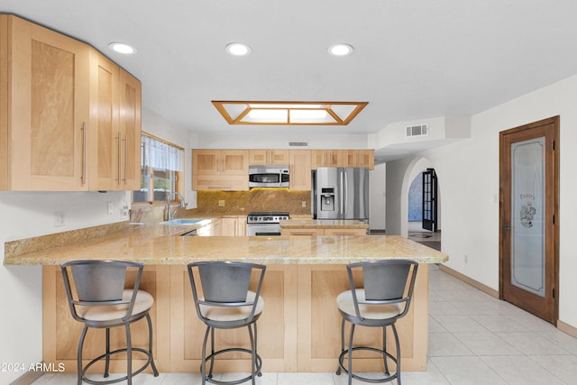 kitchen featuring arched walkways, visible vents, light brown cabinets, and stainless steel appliances