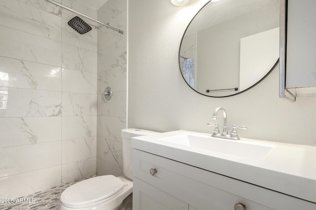 full bathroom featuring tiled shower, toilet, and vanity