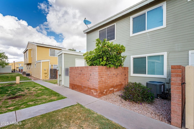 view of home's exterior with a gate, cooling unit, fence, and a yard