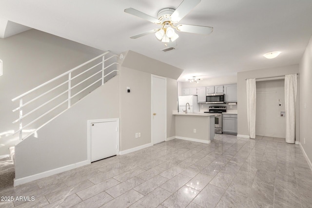 unfurnished living room with visible vents, baseboards, stairs, marble finish floor, and a ceiling fan