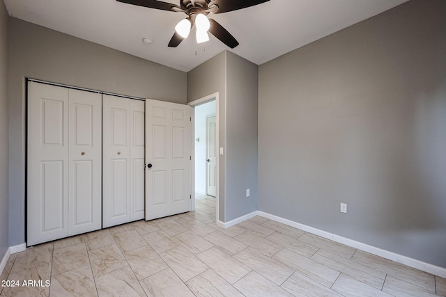 unfurnished bedroom with ceiling fan and a closet