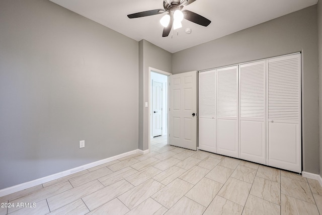 unfurnished bedroom with ceiling fan and a closet