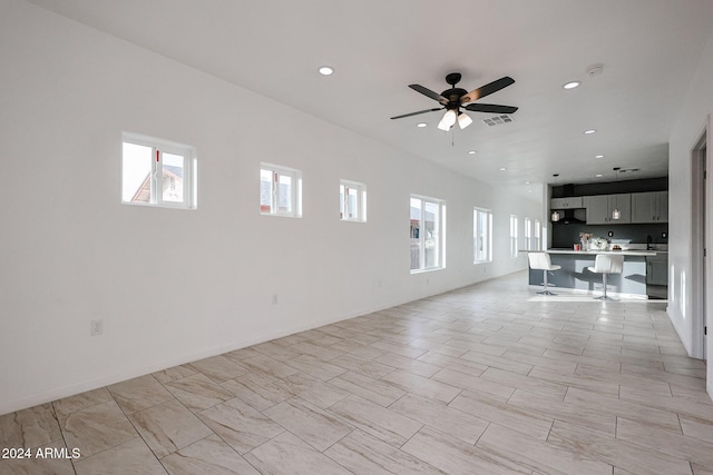 unfurnished living room with ceiling fan