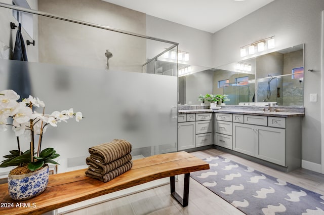 bathroom featuring hardwood / wood-style floors, vanity, and an enclosed shower